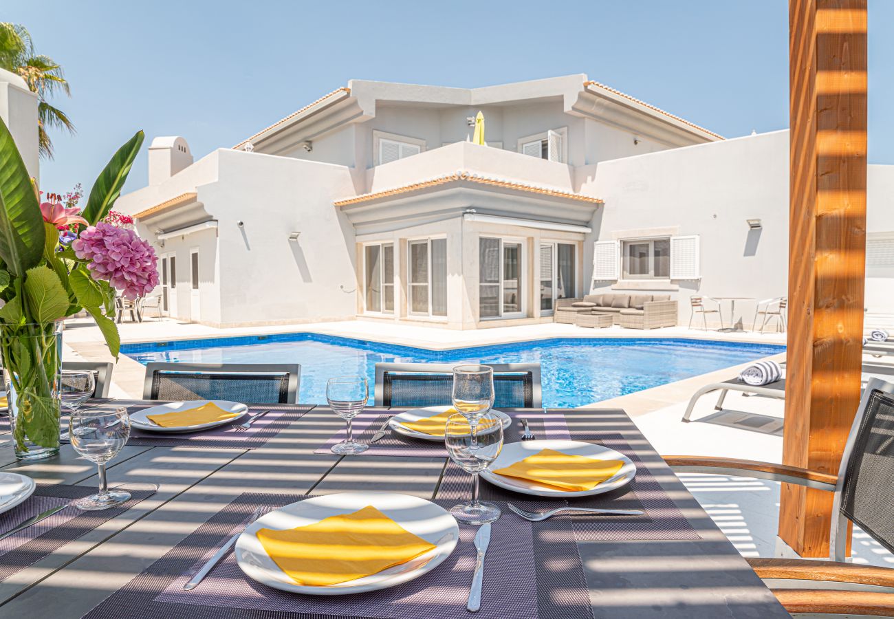 Comedor en el espacio exterior con vistas a la piscina.