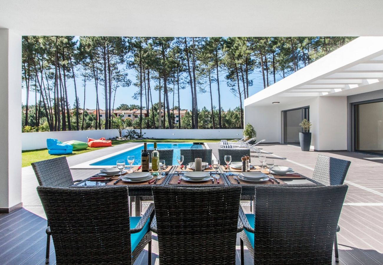 Comedor exterior con vistas al jardín y piscina.