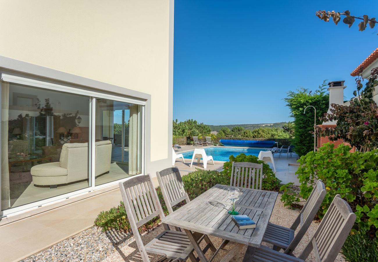 Espacio para comer al aire libre con vista a la piscina.