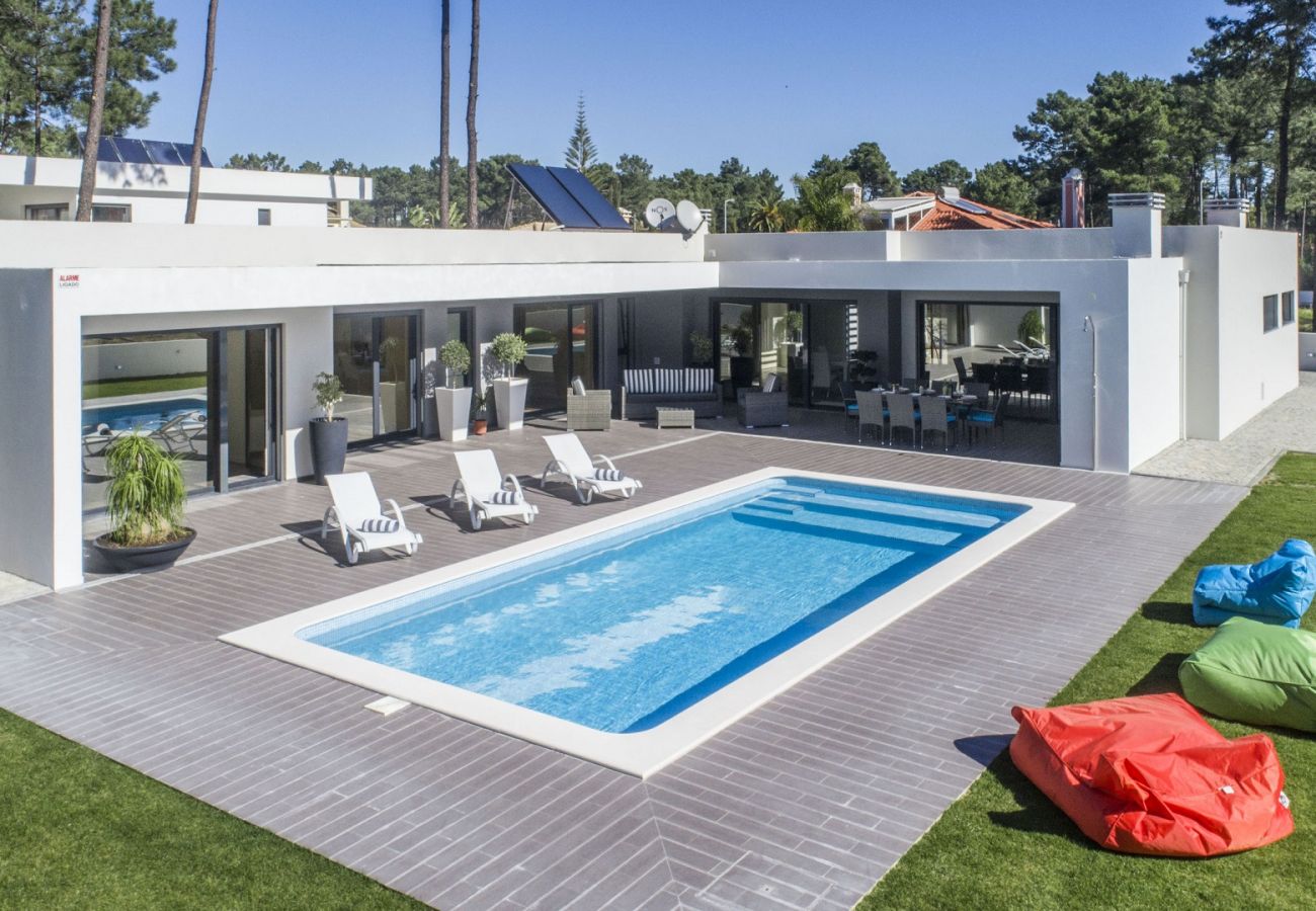 Maison entourée d'espaces extérieurs, avec piscine et jardin.