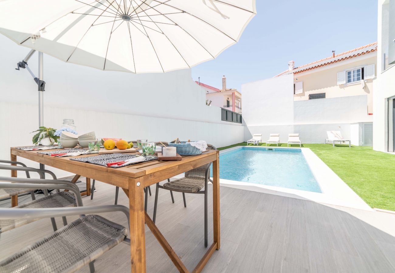 Coin repas extérieur dans le jardin près de la piscine.