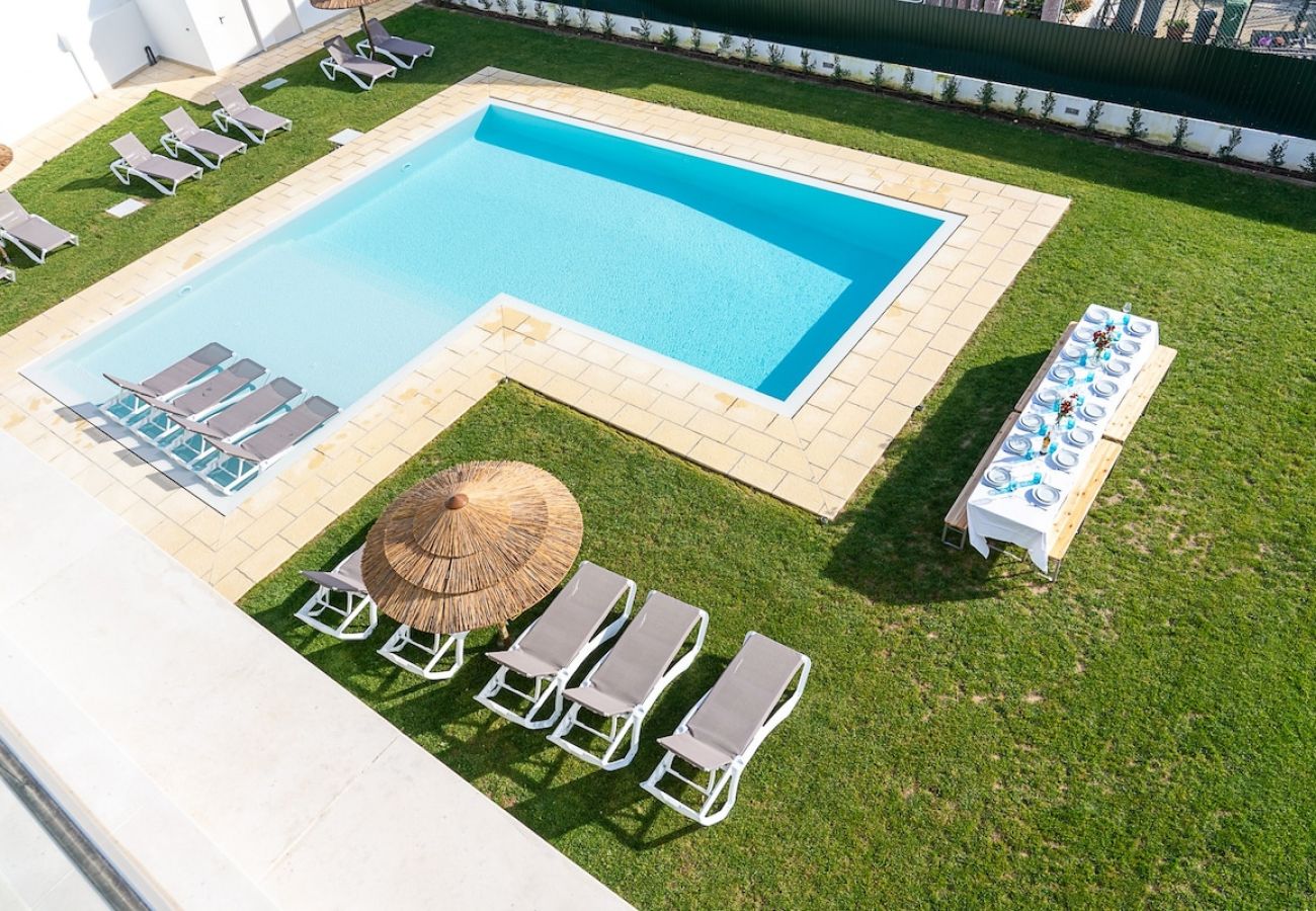 Espaço exterior com zona de piscina, lazer e zona de refeições. 