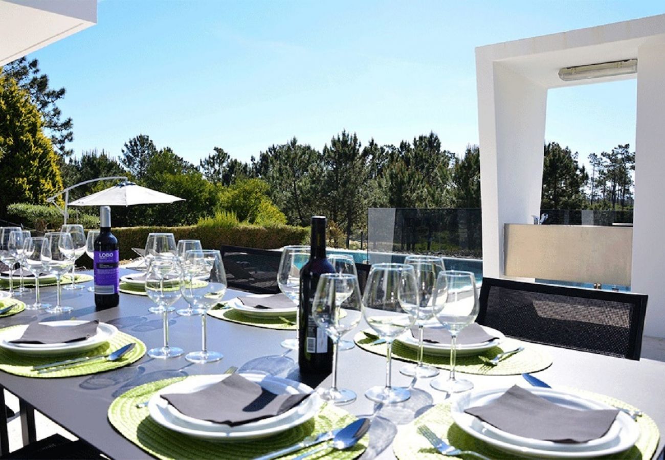 Zona de refeições no jardim com vista para a piscina.