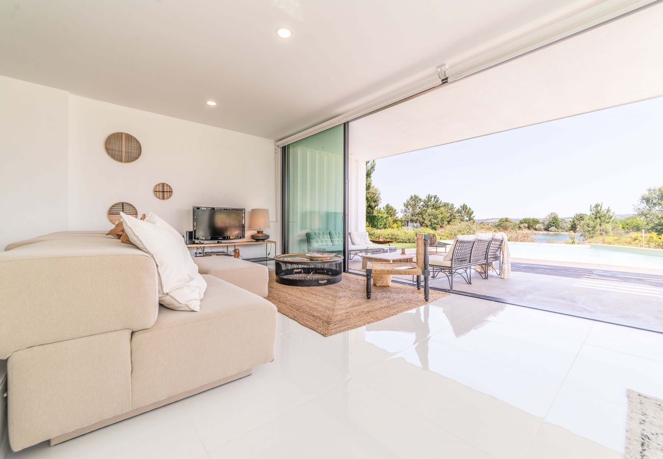 Sala com vista para o jardim e para a piscina.