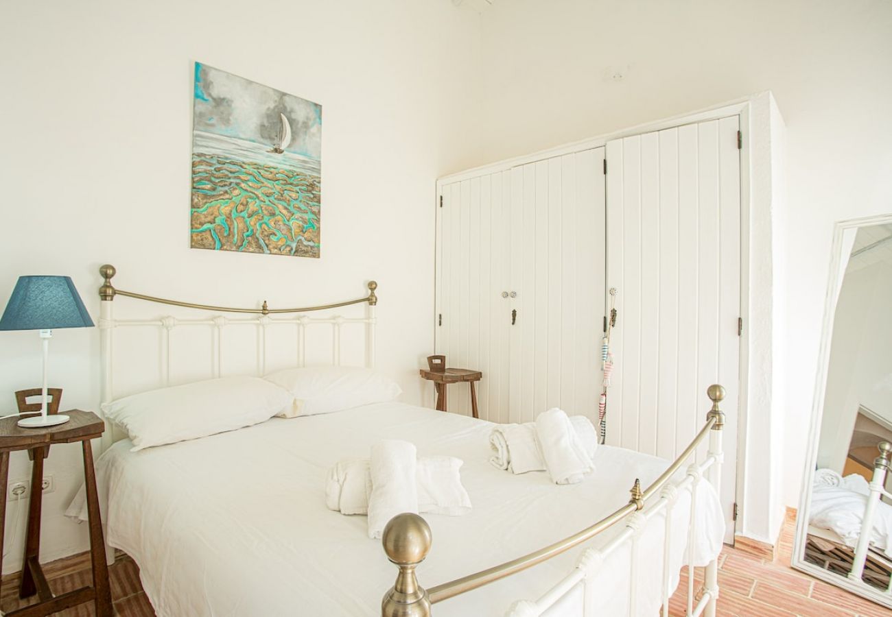 Discover the charm of the cozy rustic bedroom at Quinta da Alfazema in Olhão.