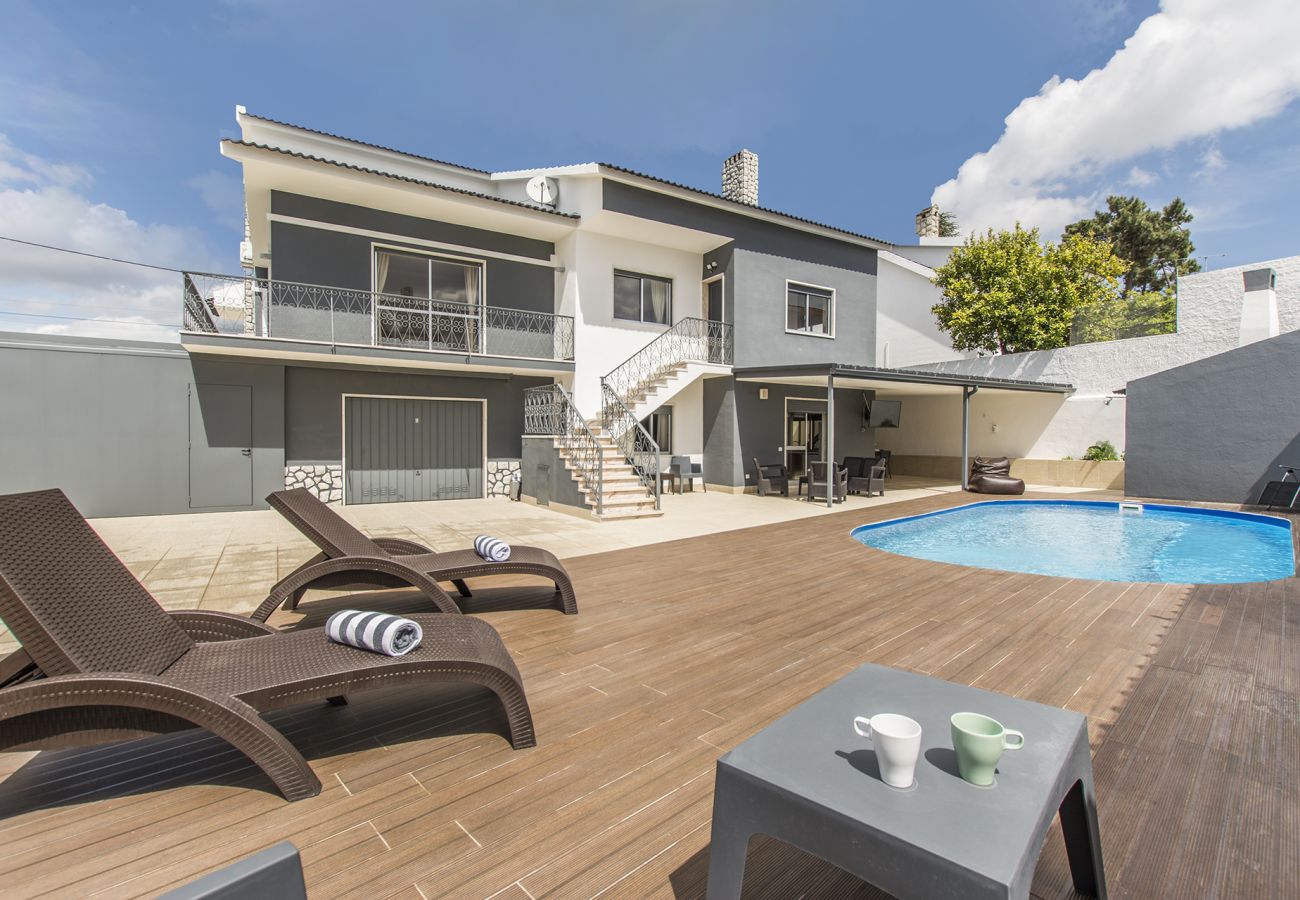 Swimming pool with sun loungers outside the house.